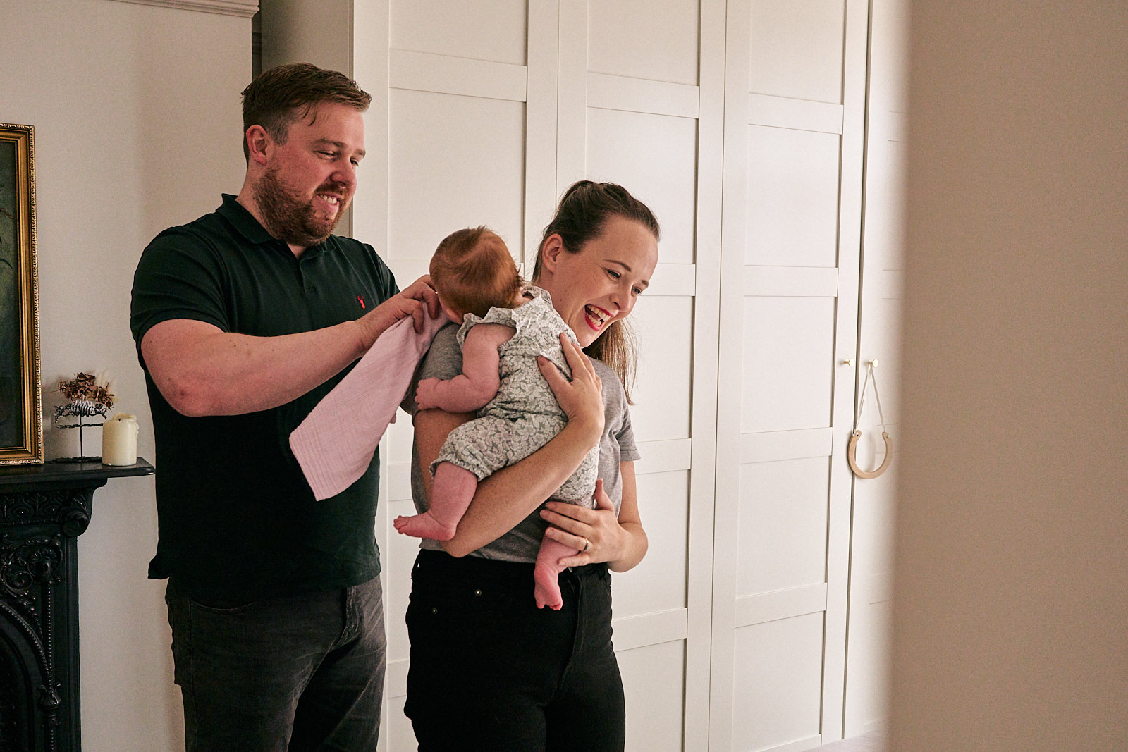 parents laugh during natural family shoot at home in wigan
