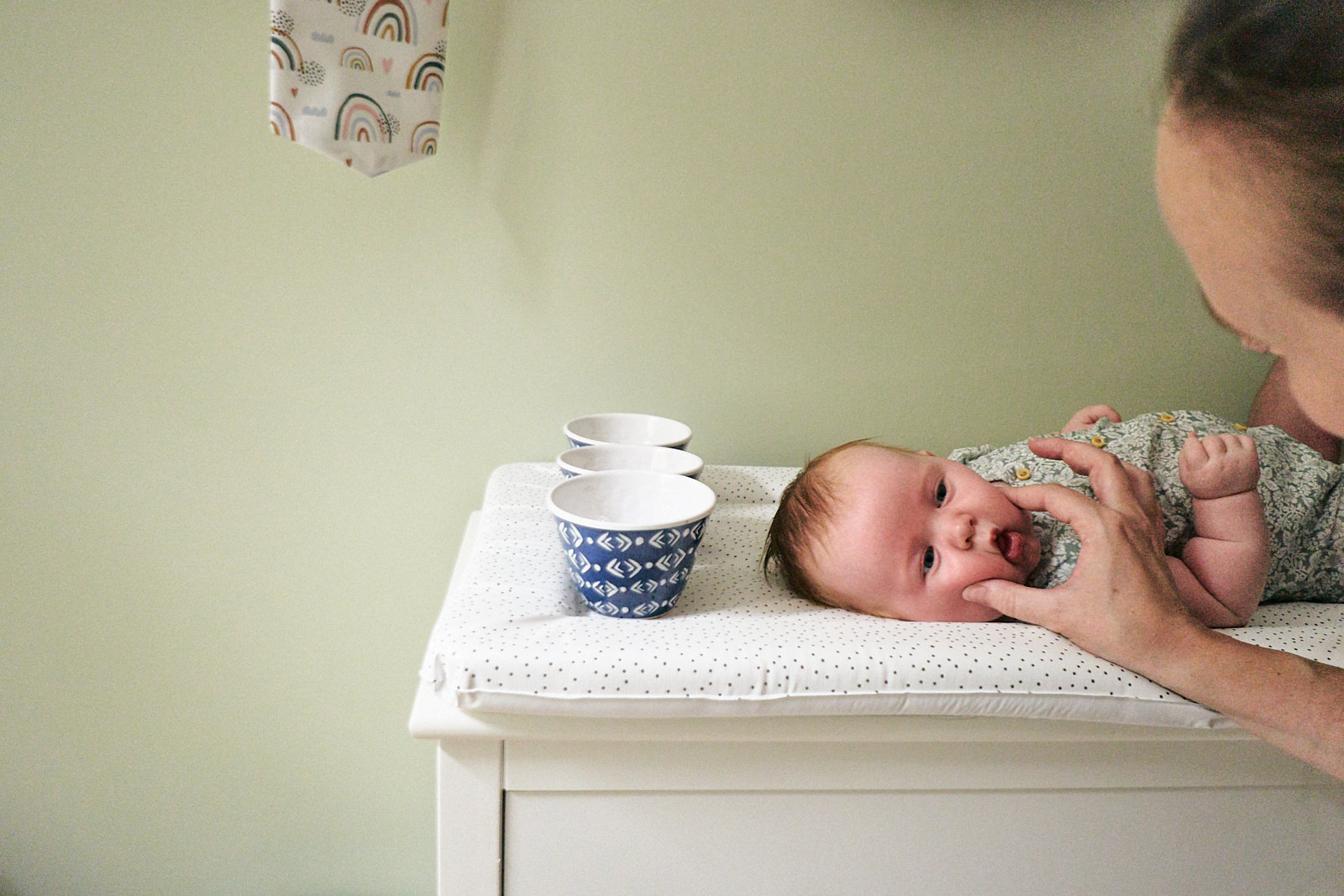 mum squishes babys cheeks for natural photo