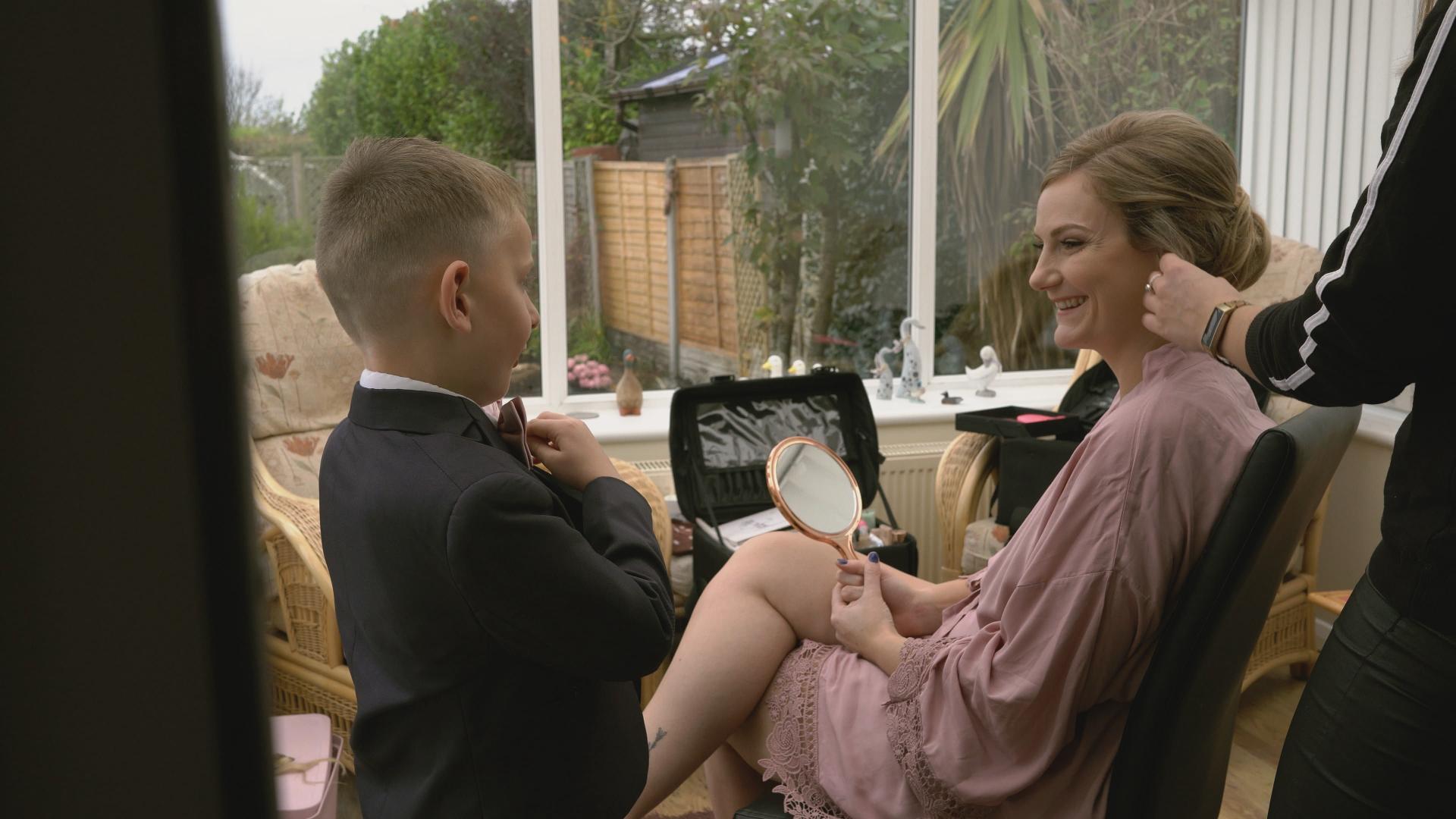 bride smiles at son in his wedding tux
