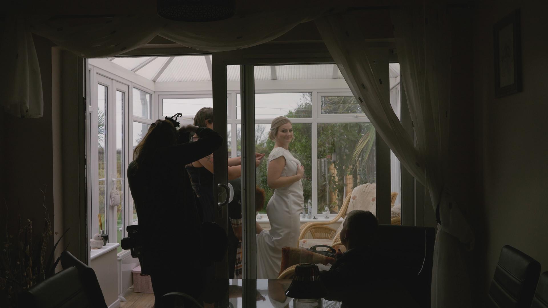 video still of bride getting in to her wedding dress in southport