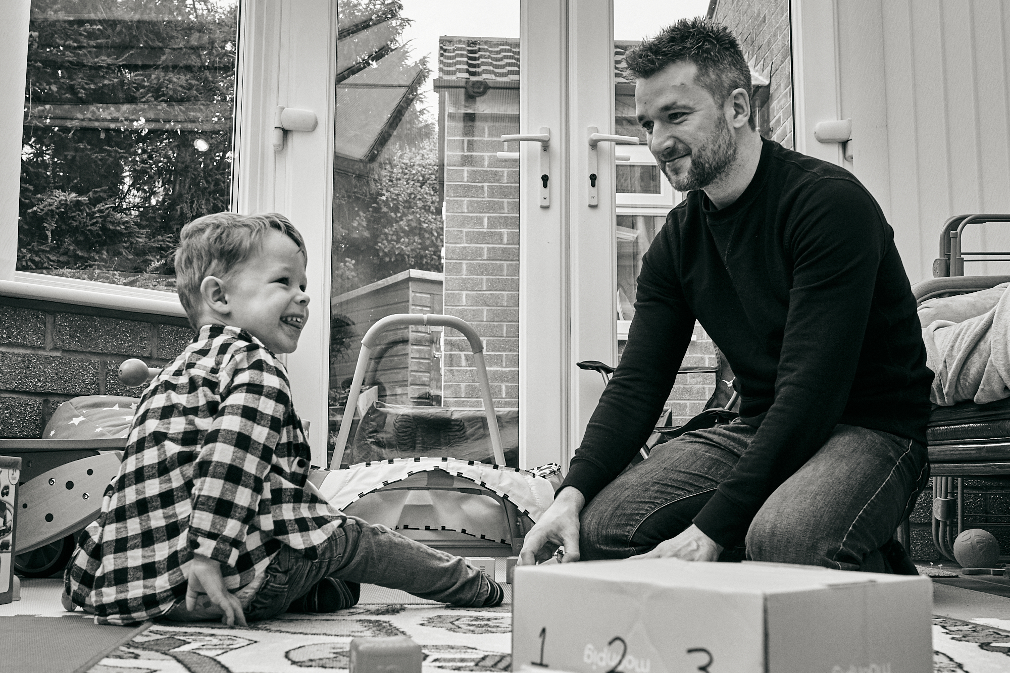 dad and toddler laugh during family photoshoot