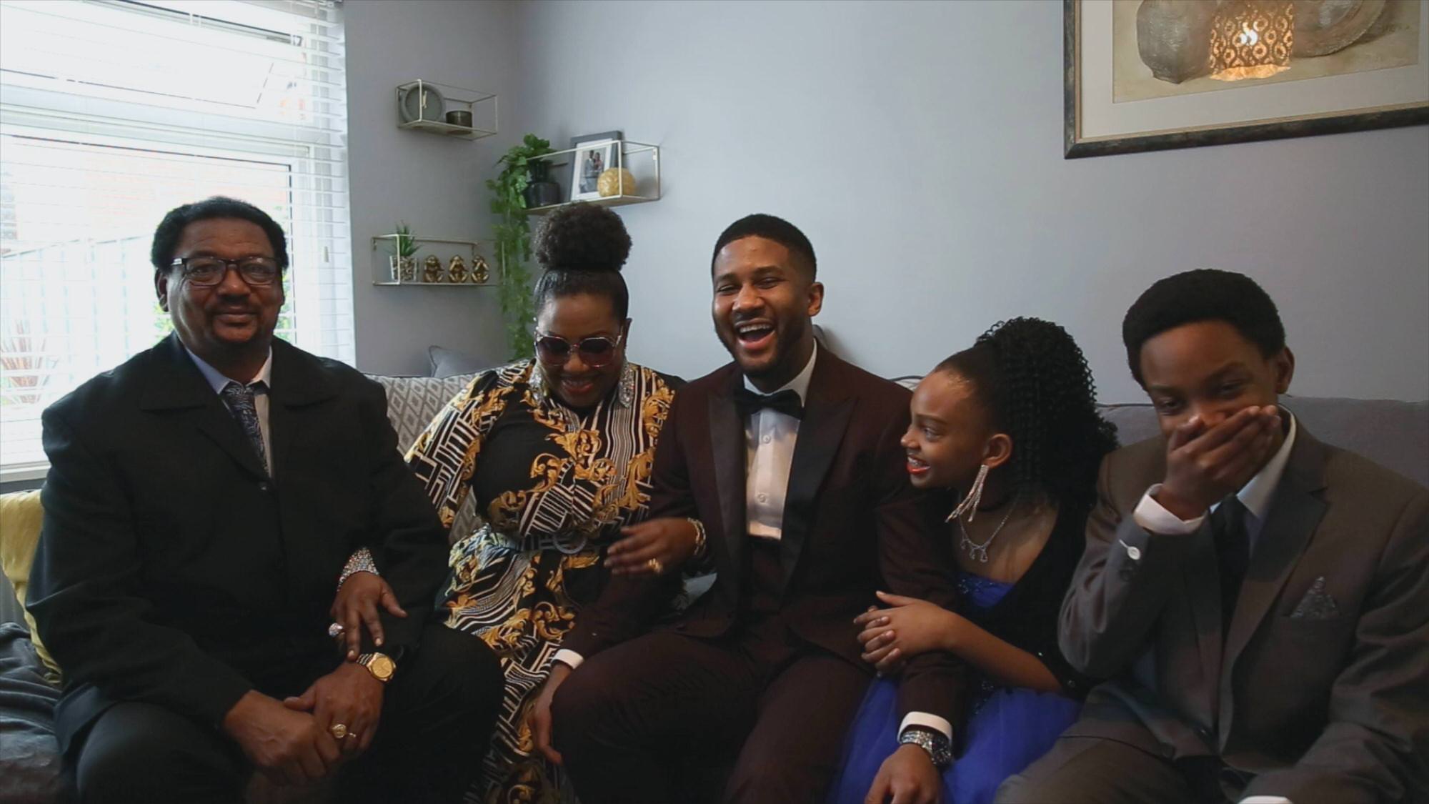 groom and his family laugh together before wedding ceremony