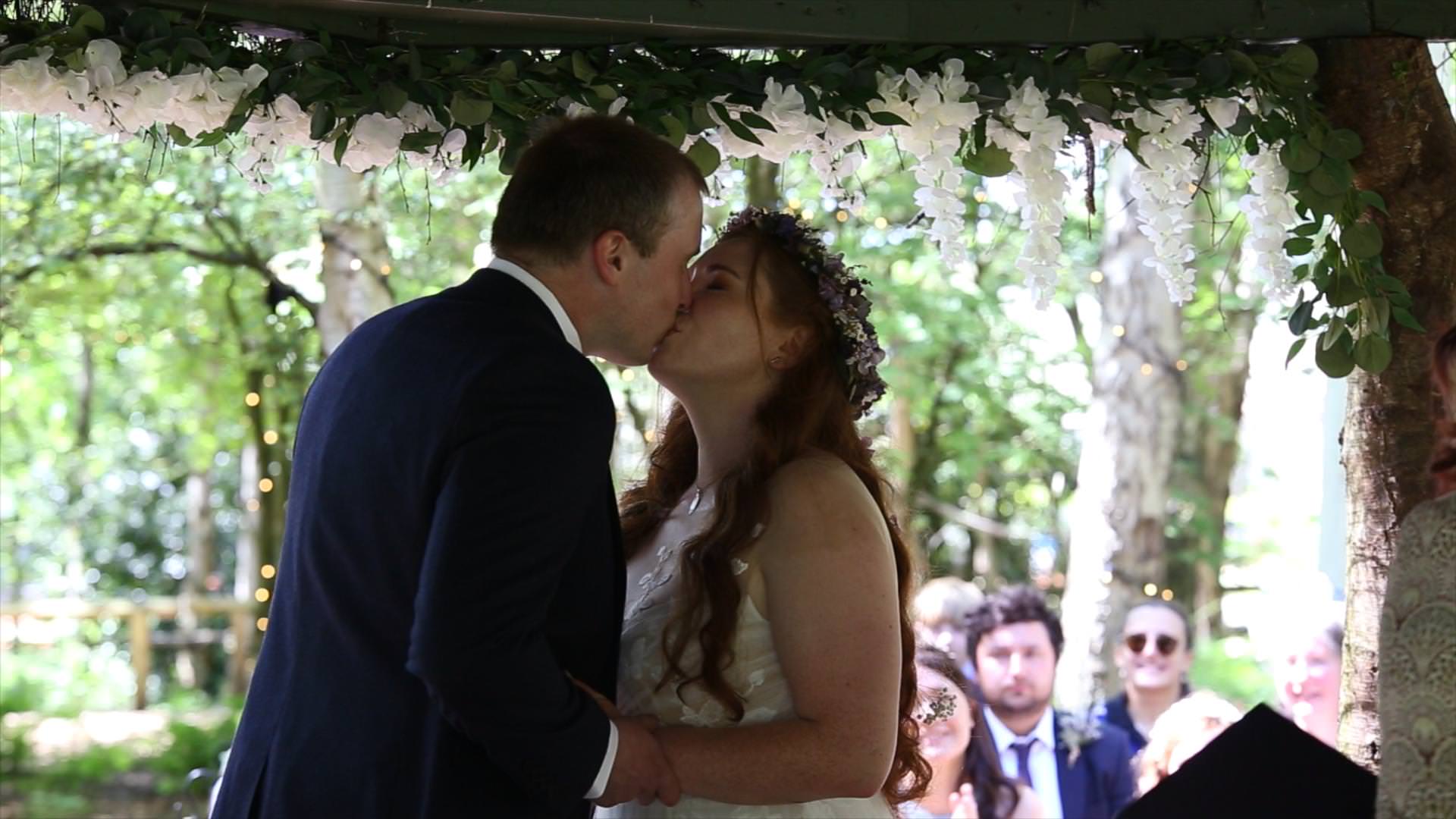 couple kiss during outdoor wedding ceremony