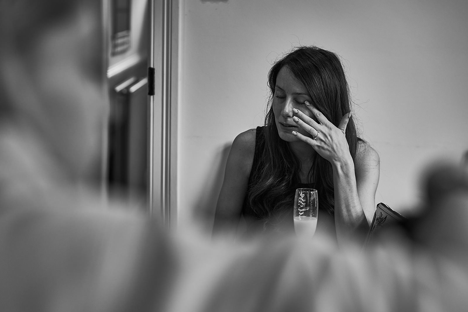 candid photo of bridesmaid wiping away tear at wedding