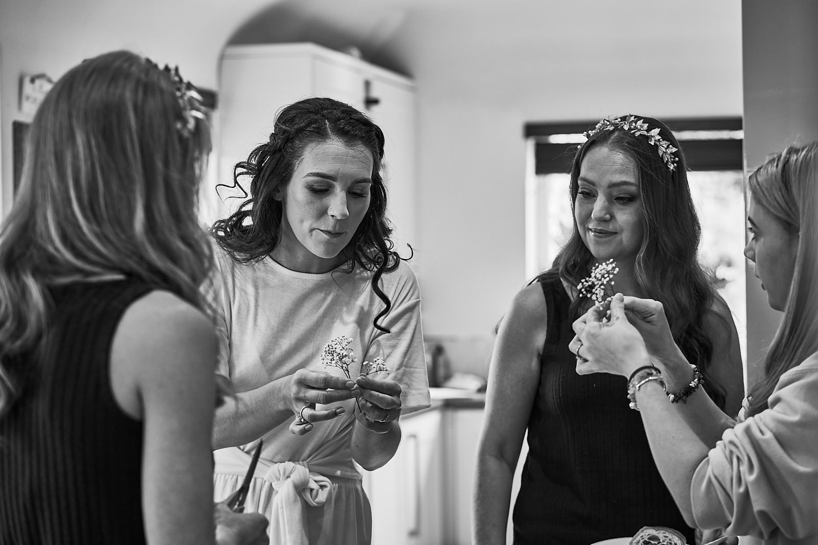 bride with bridesmaids chatting about hair flowers