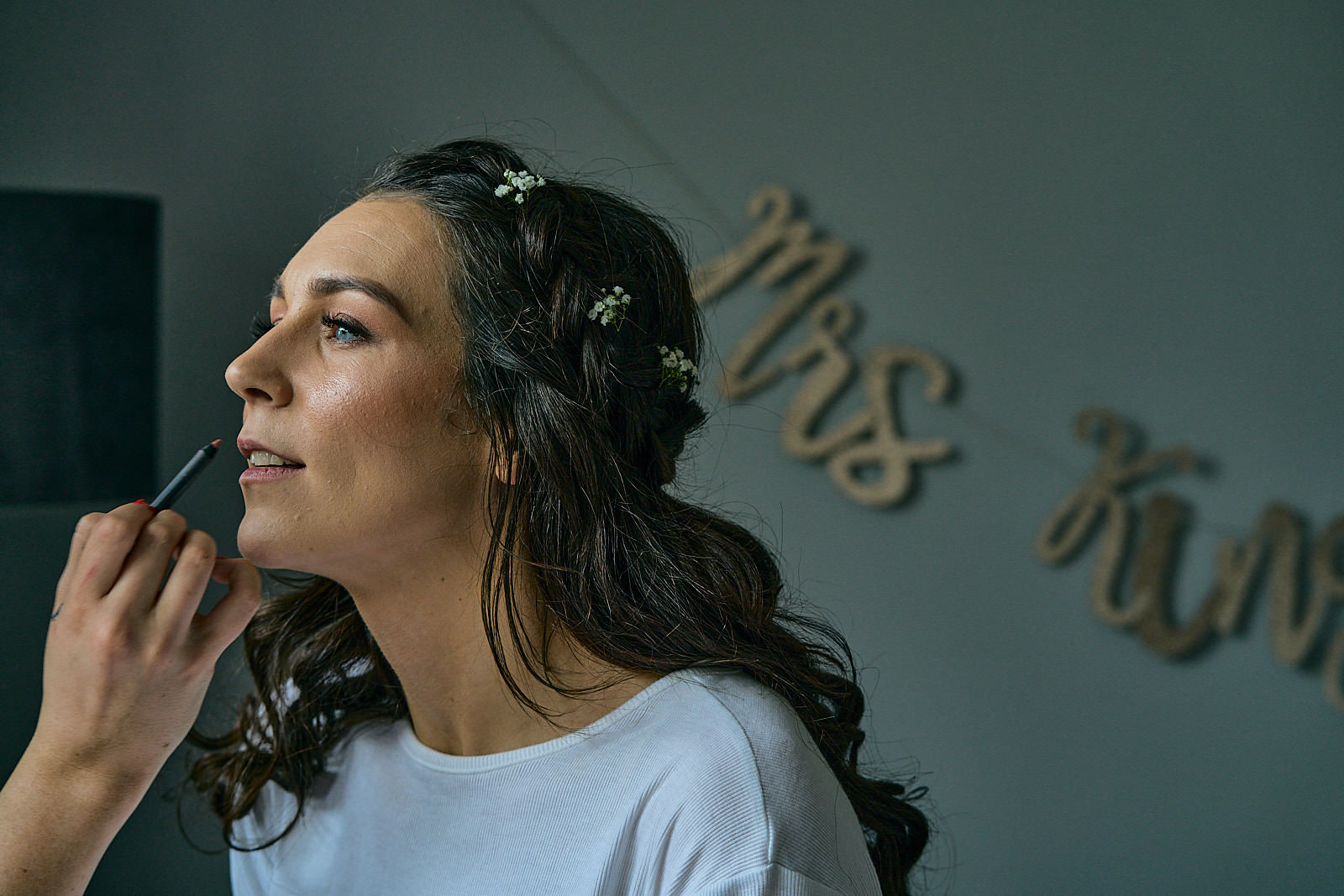 bride gets lipstick touched up on wedding morning