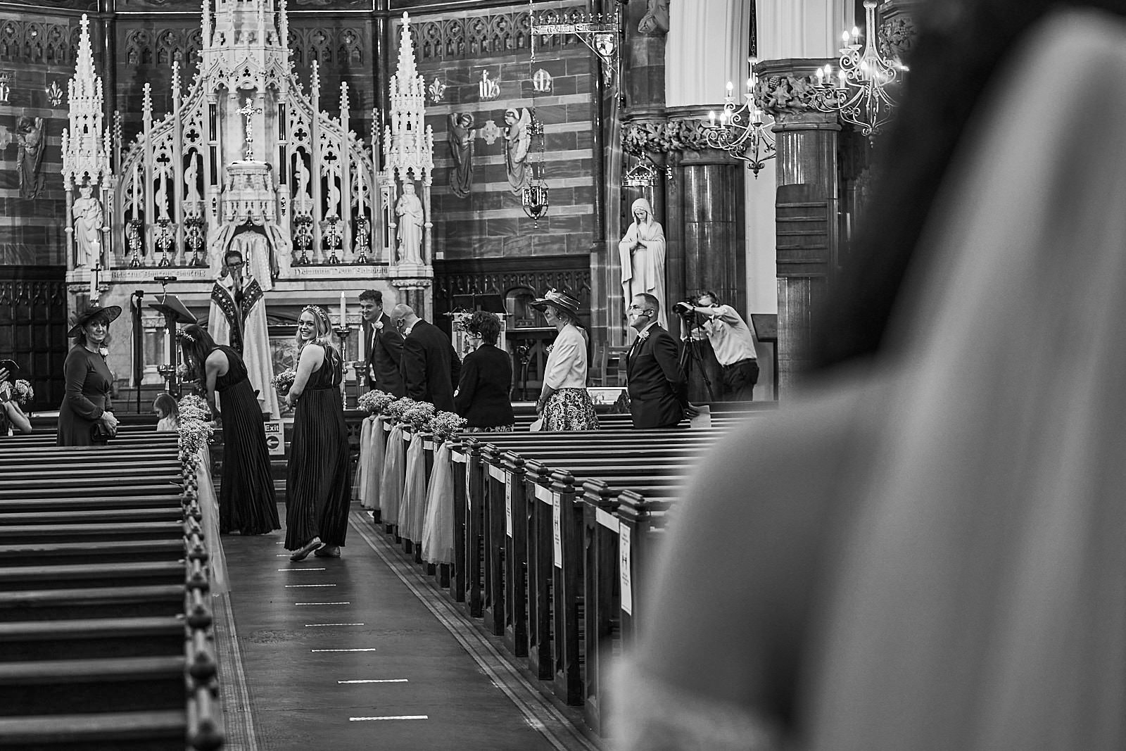 bridesmaid looks back to bride with a grin walking down aisle