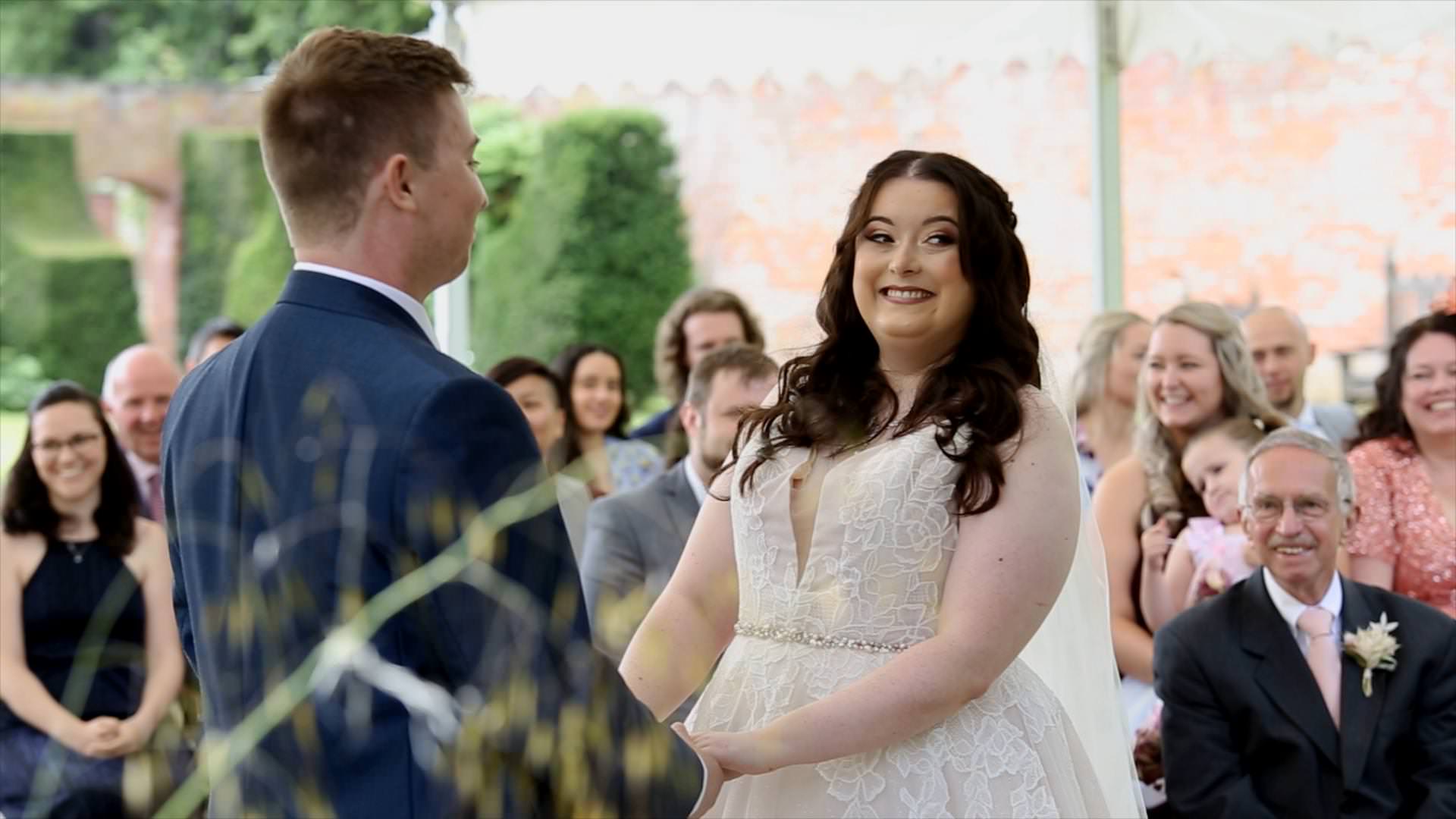 bride giggles during outdoor wedding ceremony at Combermere Abbey