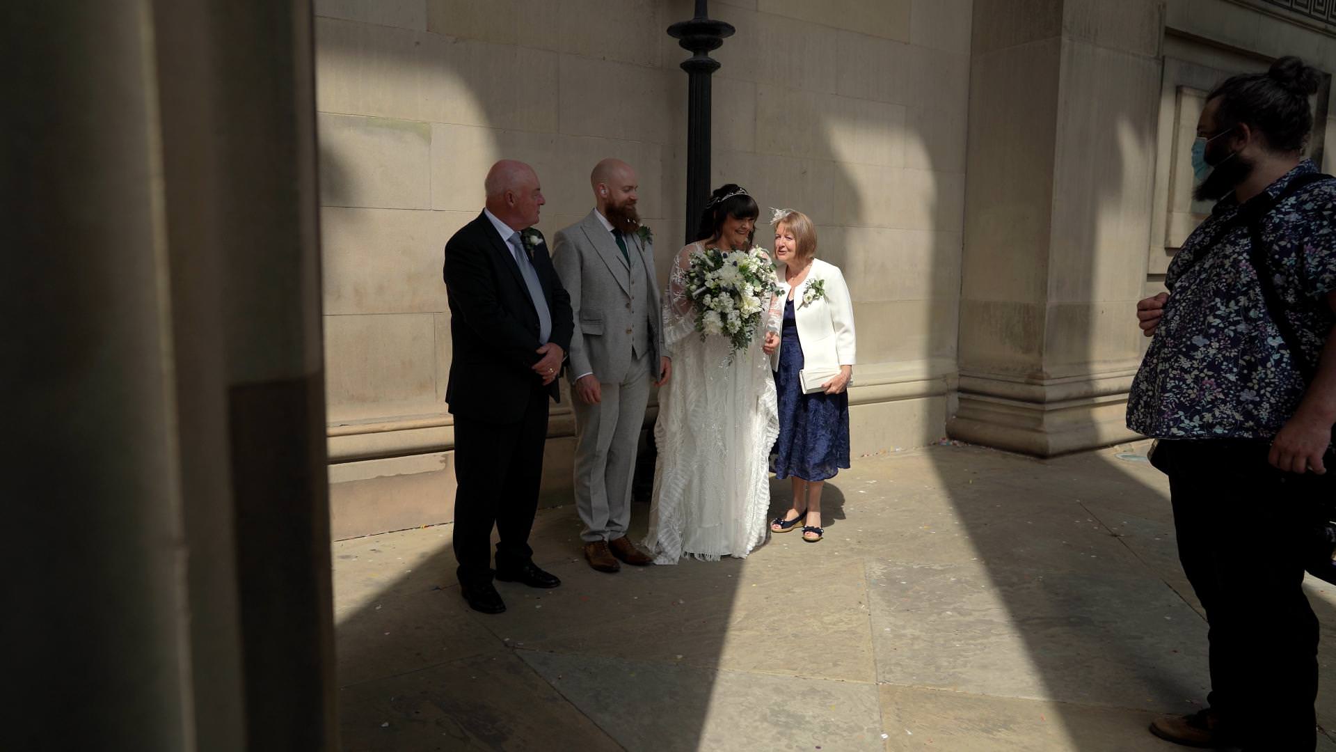couple pose for family photos outside St Georges Hall