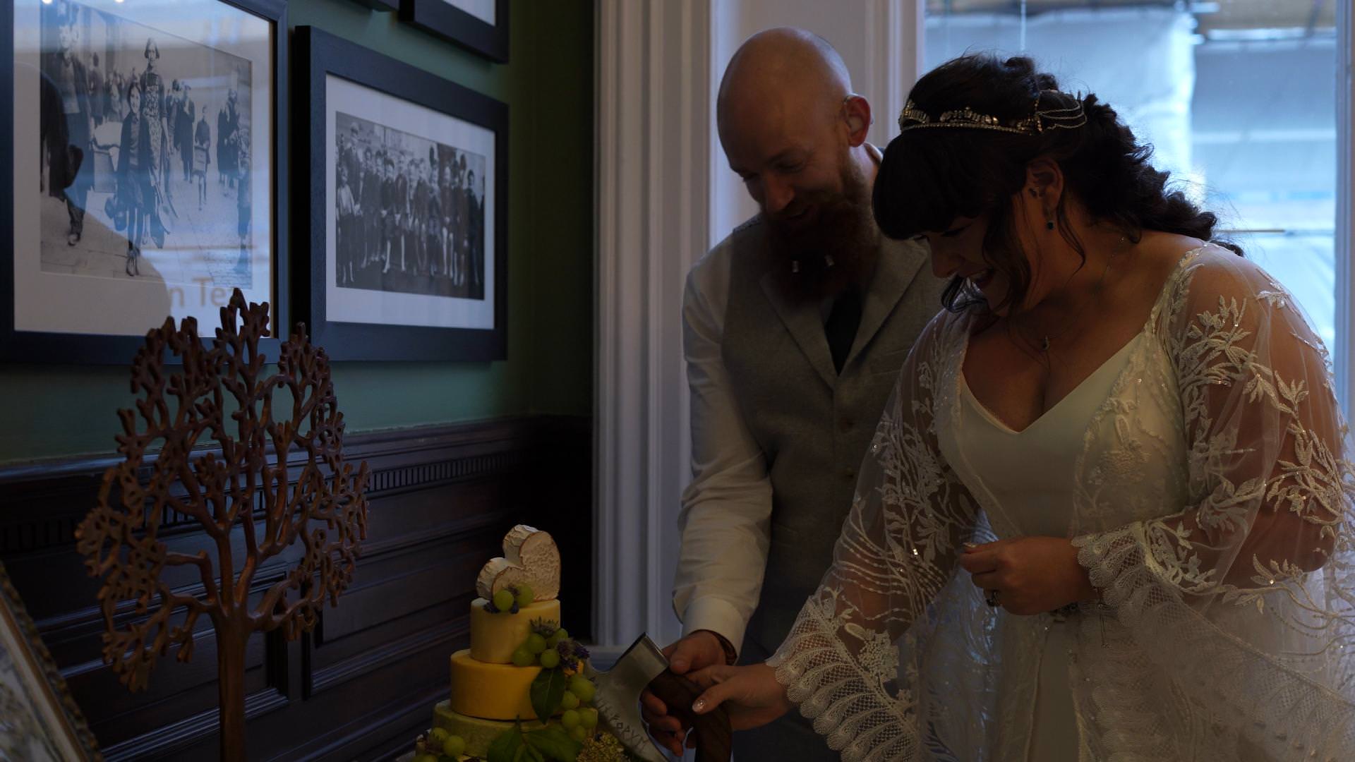 couple cut cheese cake with a viking axe