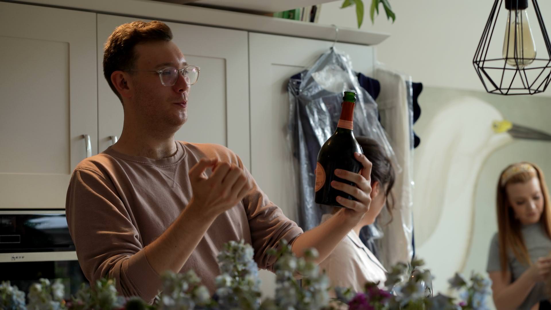 brides friend opens wedding champagne