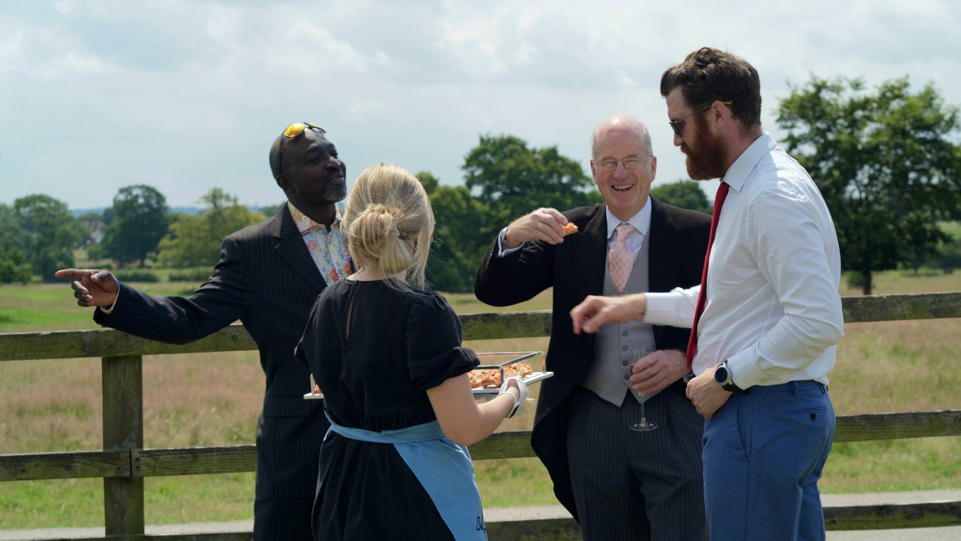 wedding guests laugh outside tipi reception
