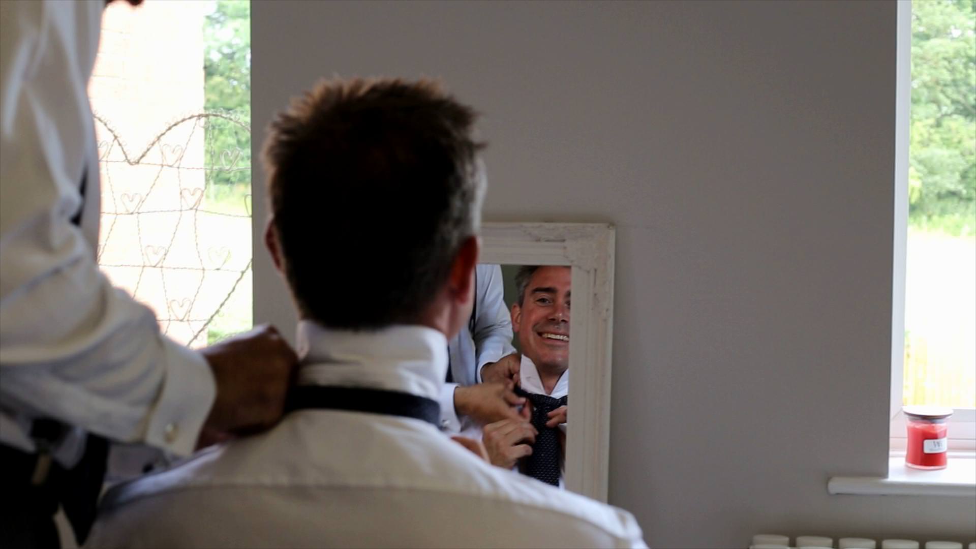 groom gets help with tie on wedding morning