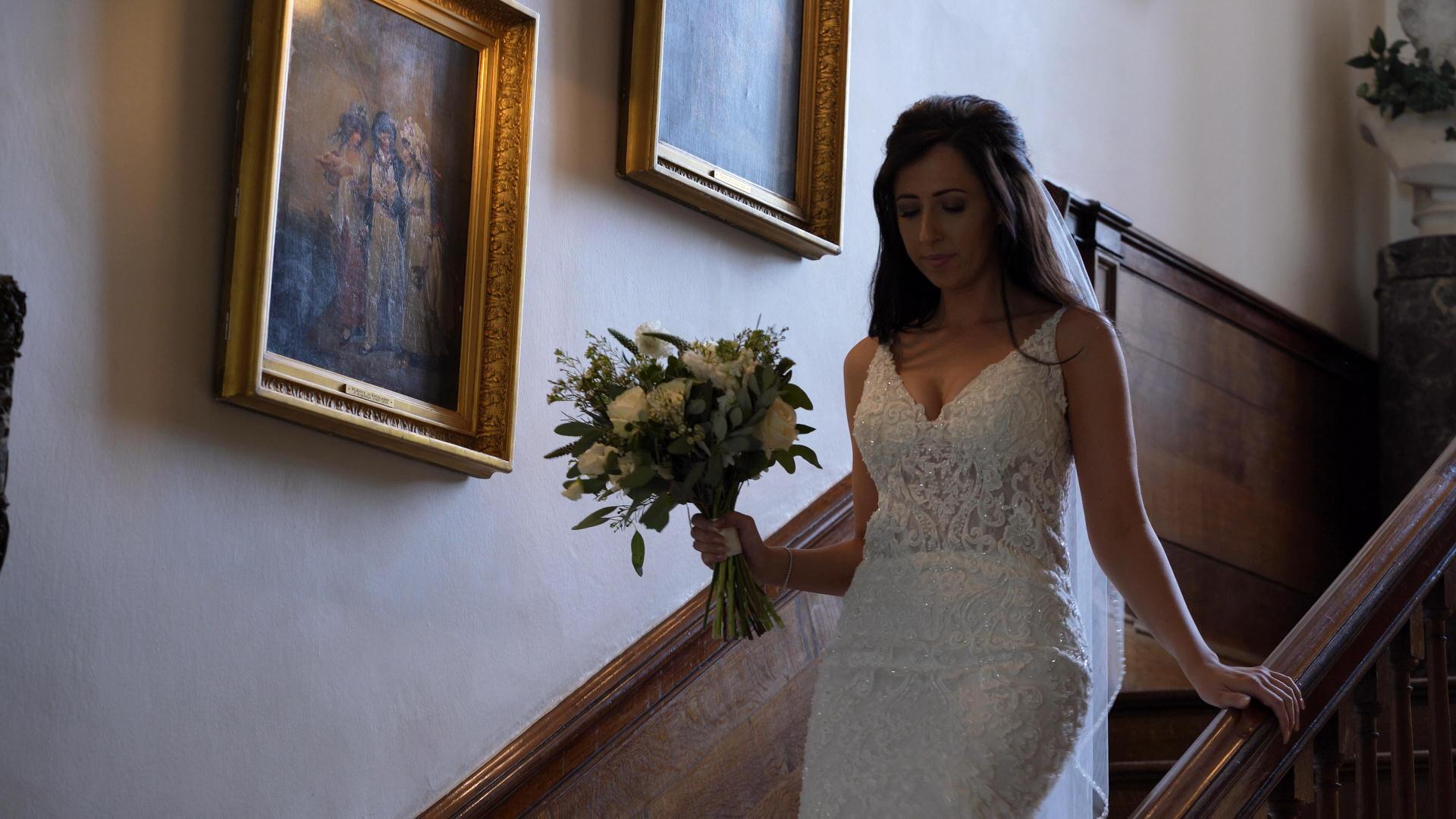 bride walks down stairs at Iscoyd Park