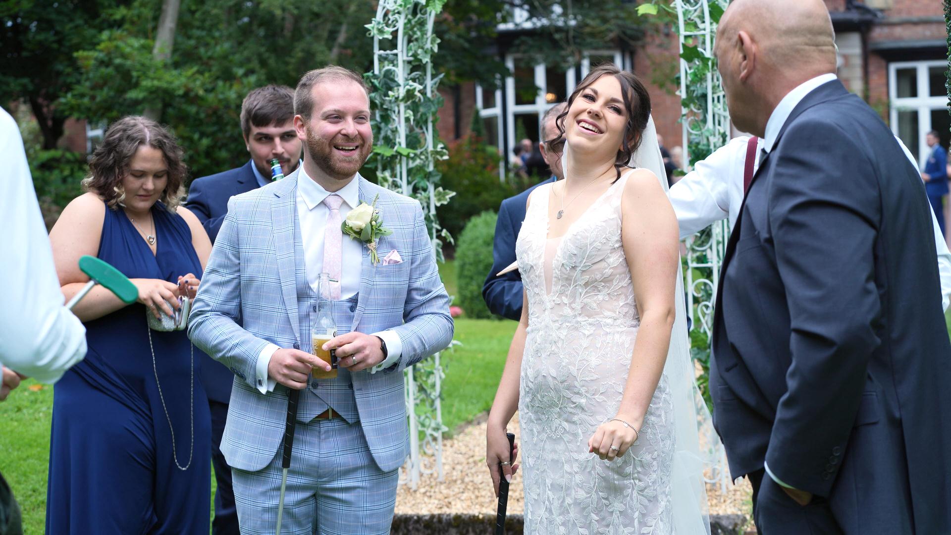 couple laugh with golf clubs during crazy 9 mini golf at wedding