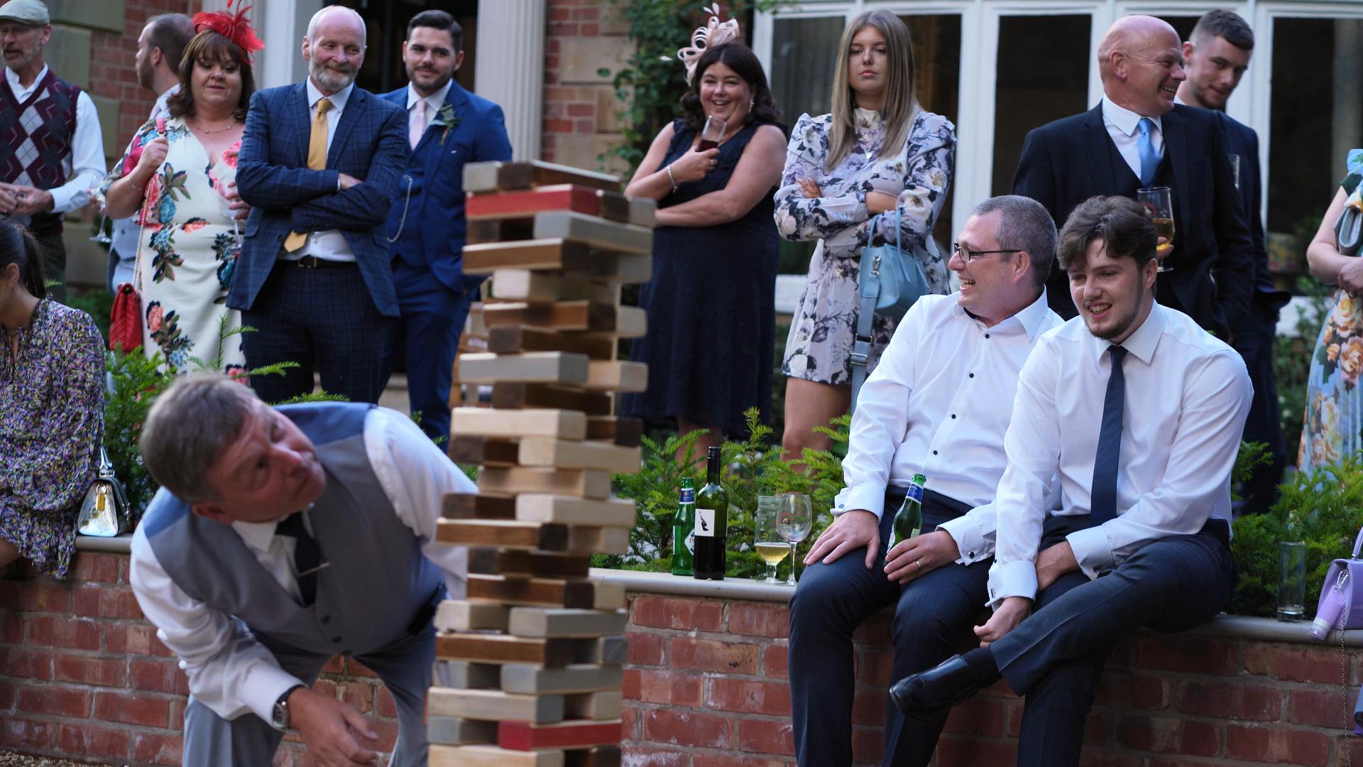 wedding guests crowd around Crazy 9 giant jenga game