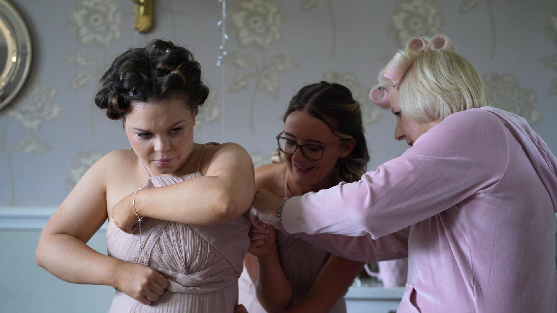 bridesmaid getting help with her dress