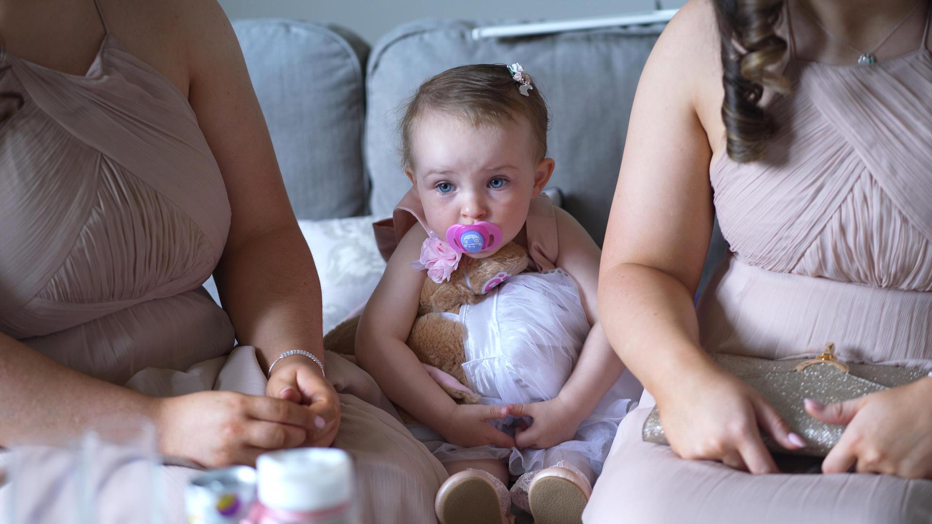 tired flower girl sits on sofa