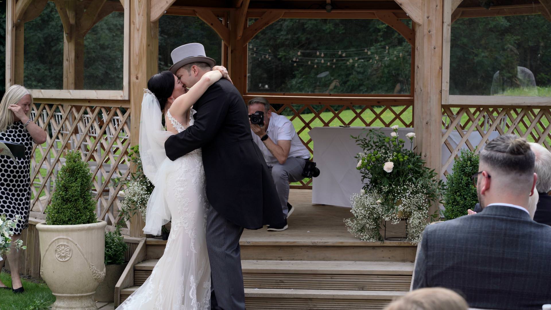 couple kiss during outdoor ceremony at Whitley Hall