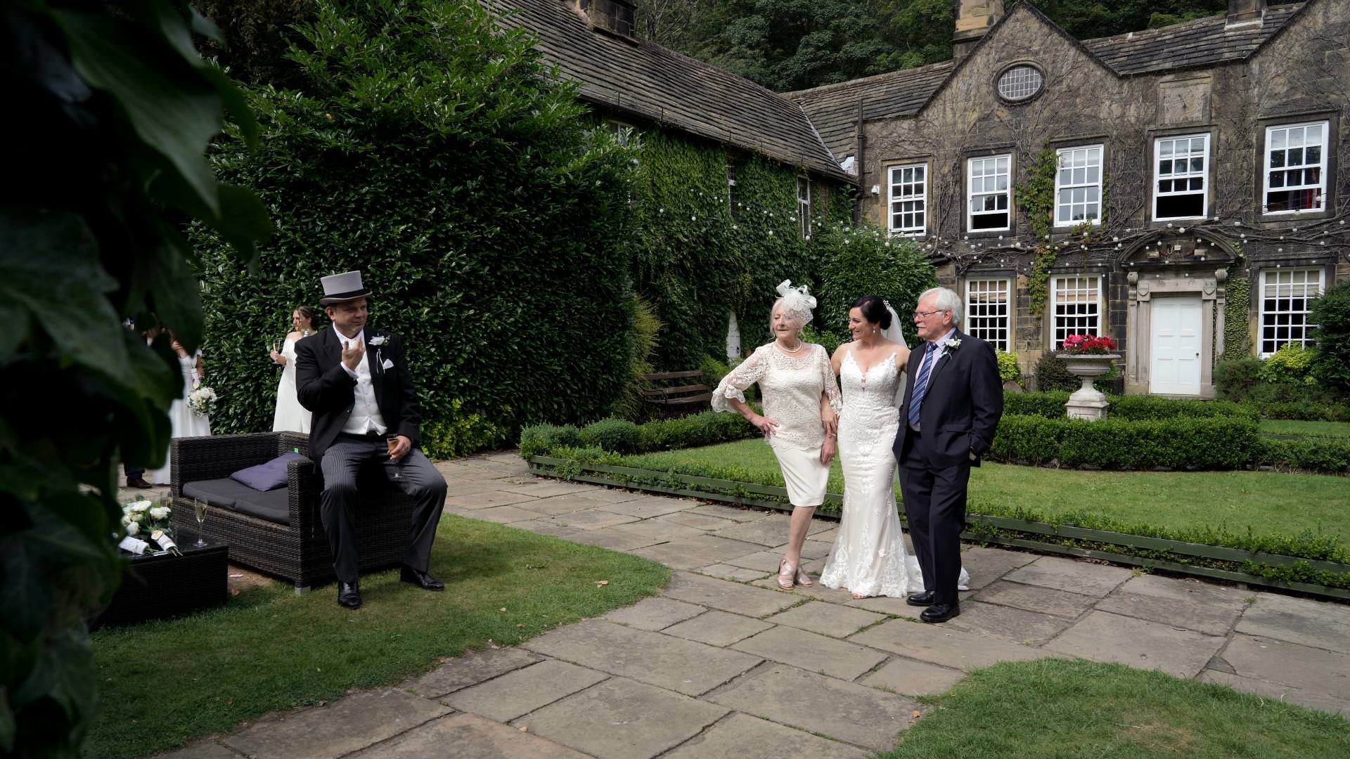 wedding guests pose for photos outside Whitley Hall