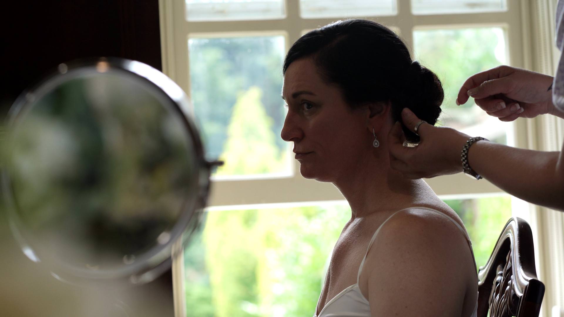 close up video still of bride getting hair done at Whitley