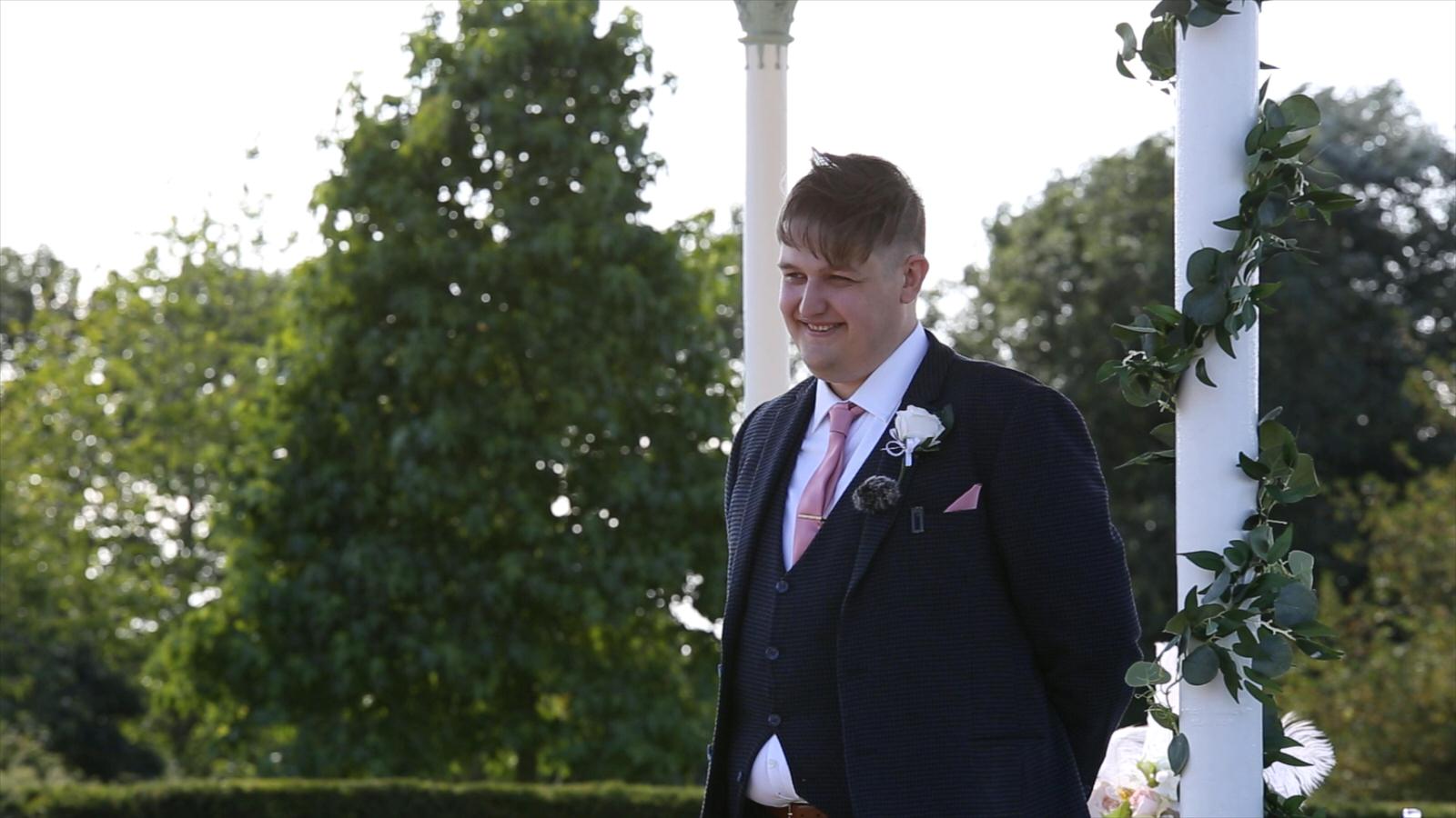 groom smiles as he sees bride walk down the aisle