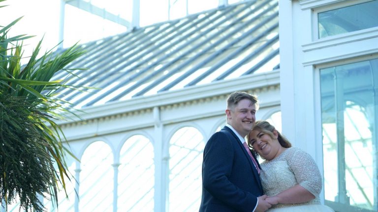 bride gently leans on groom in liverpool sunshine