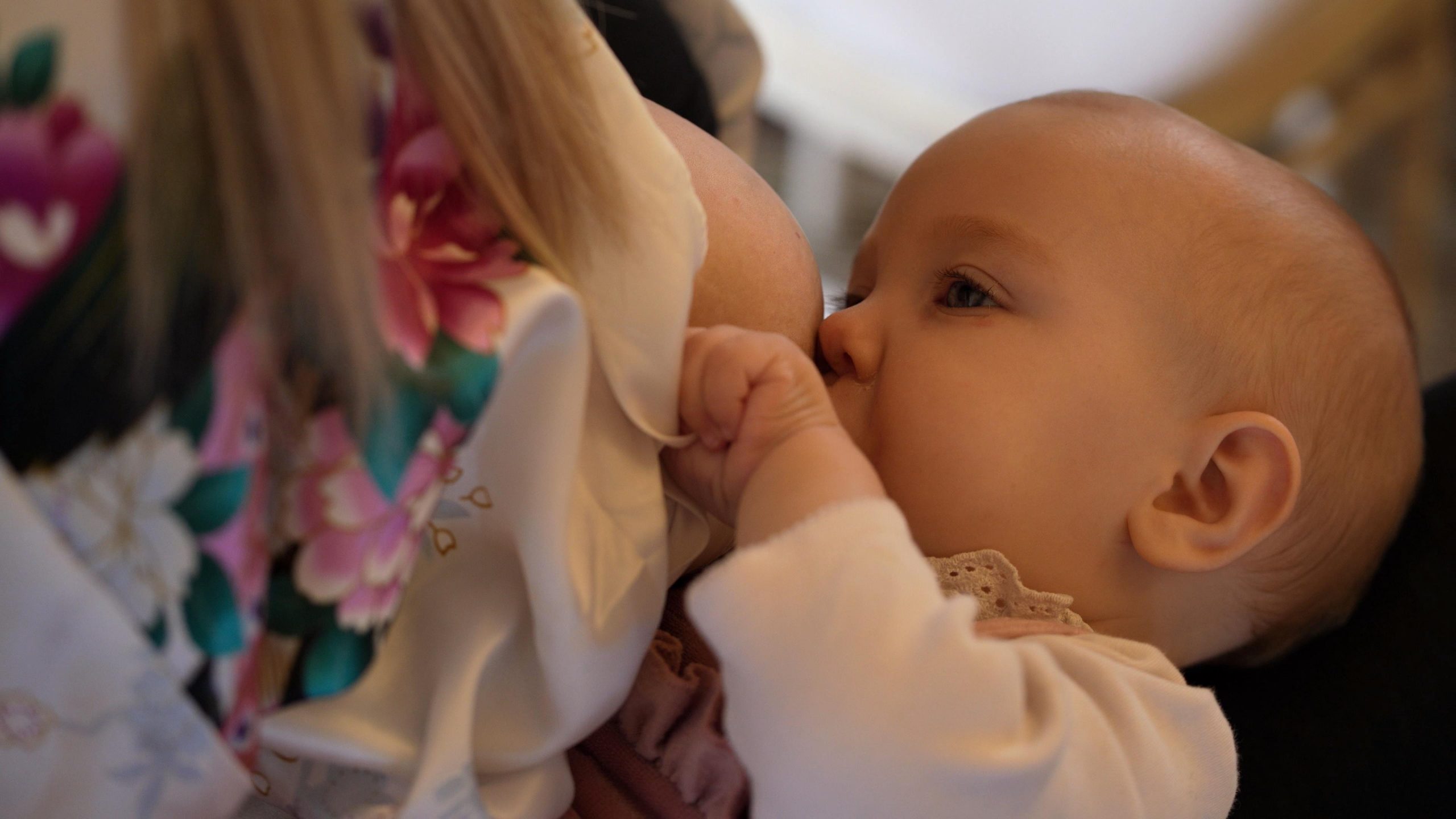 bride breastfeeds baby during wedding morning