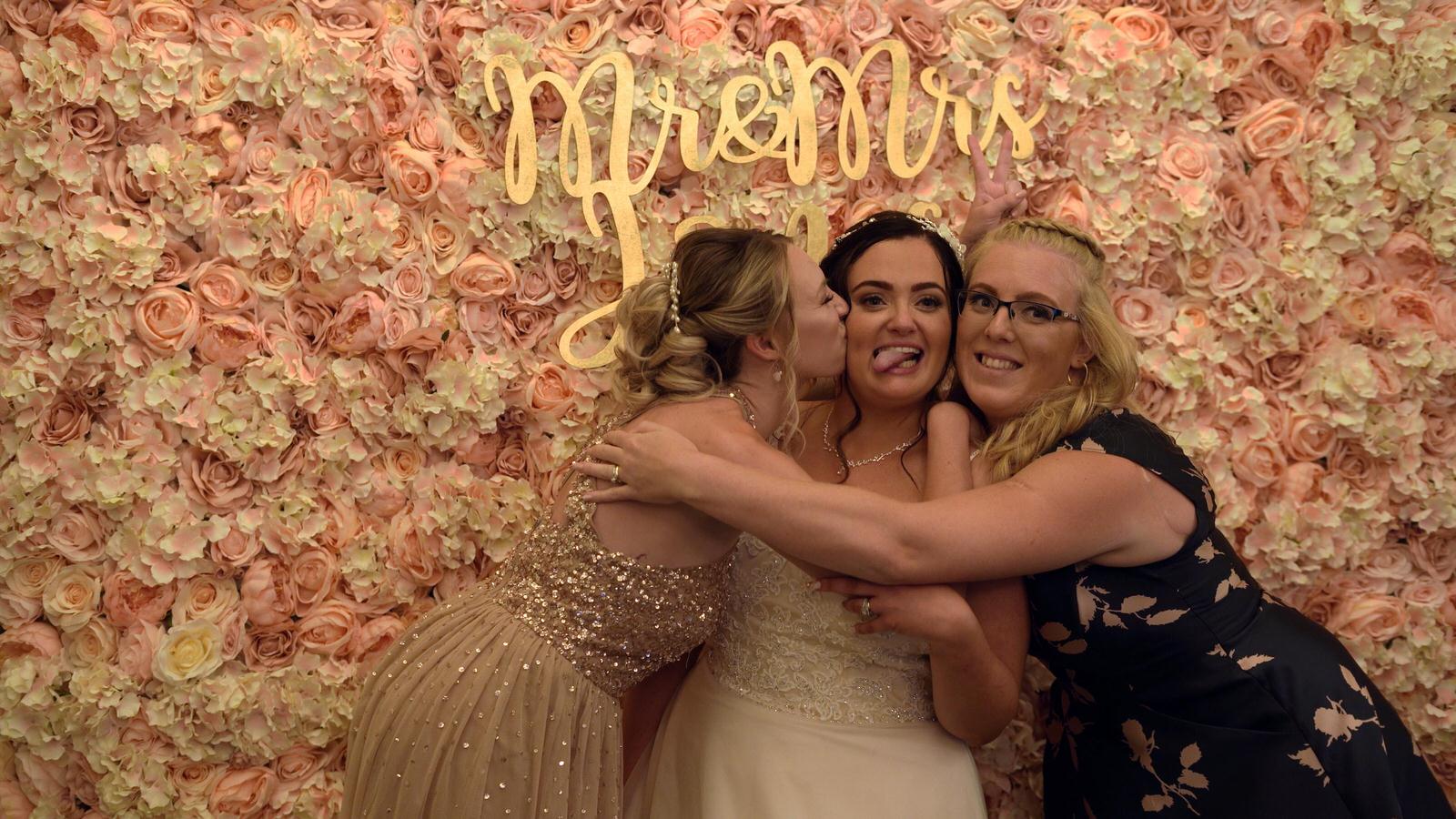 bride poses with friends for photobooth