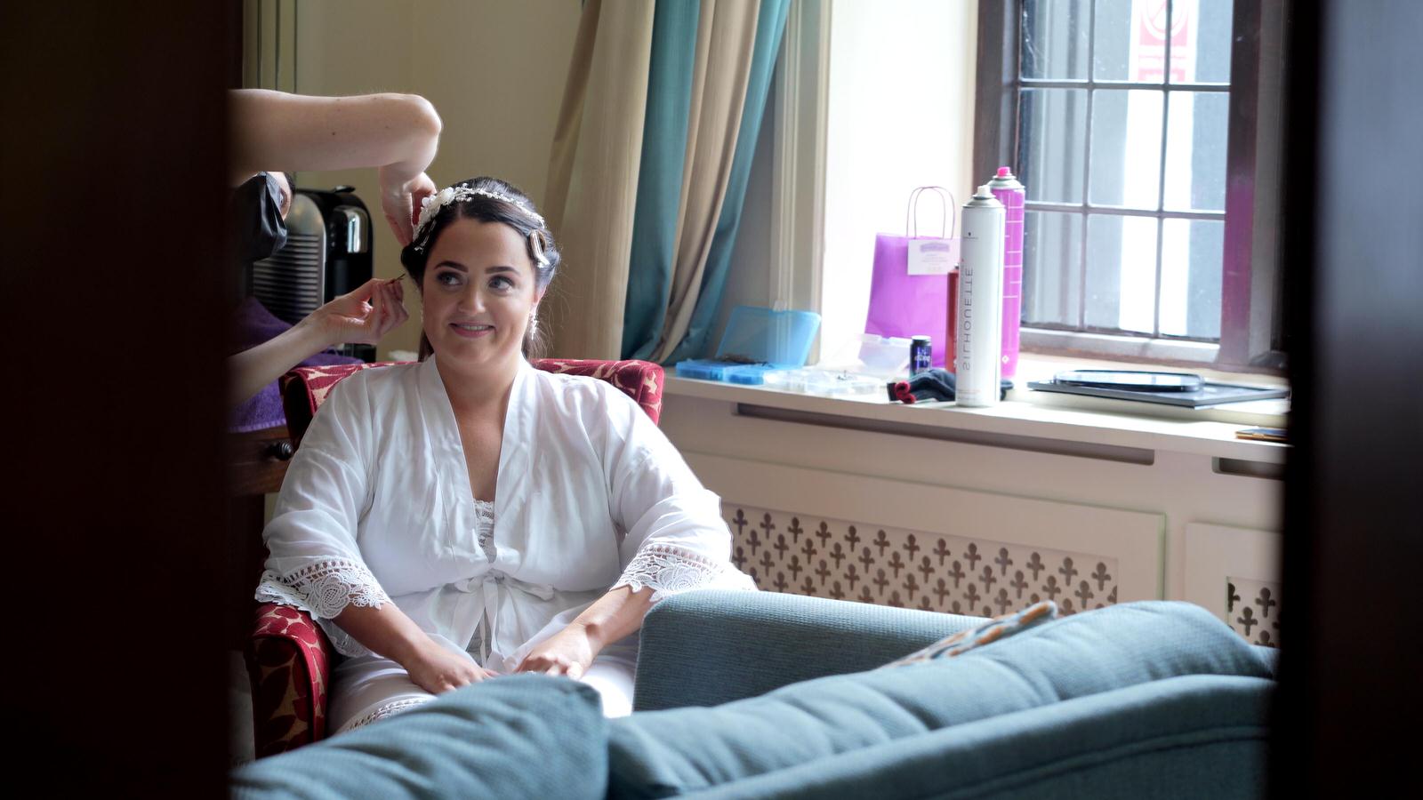 bride smiles as she has her hair done