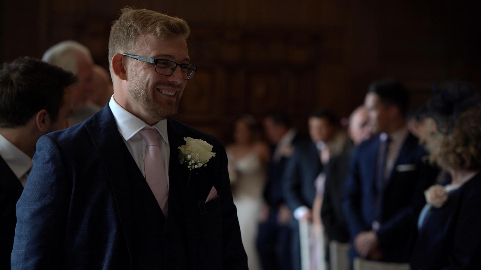 groom smiles as he waits for bride to walk down aisle