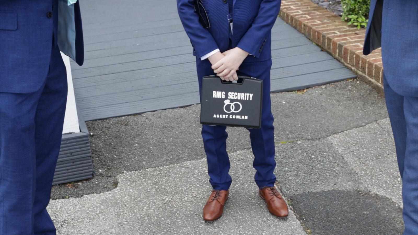 page boy holds wedding ring security box