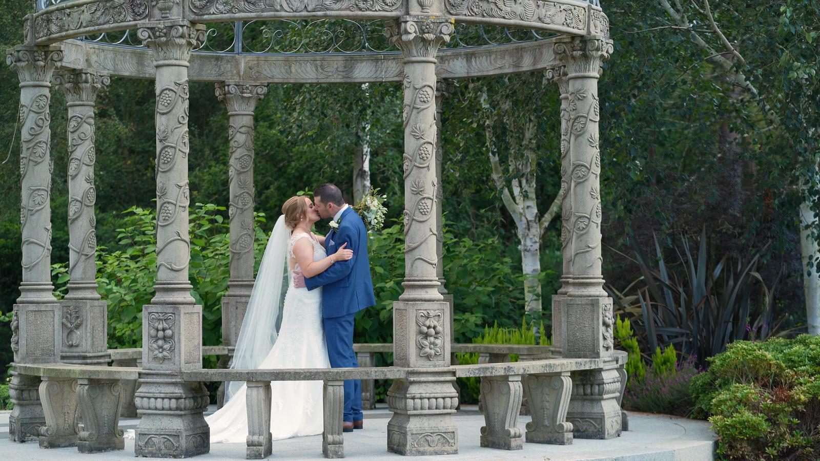 bride and groom kiss under pagoda outside Hillbark Hotel