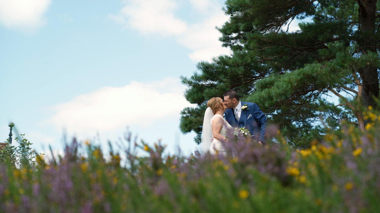 newlywed couple in long grass outside hillbark hotel