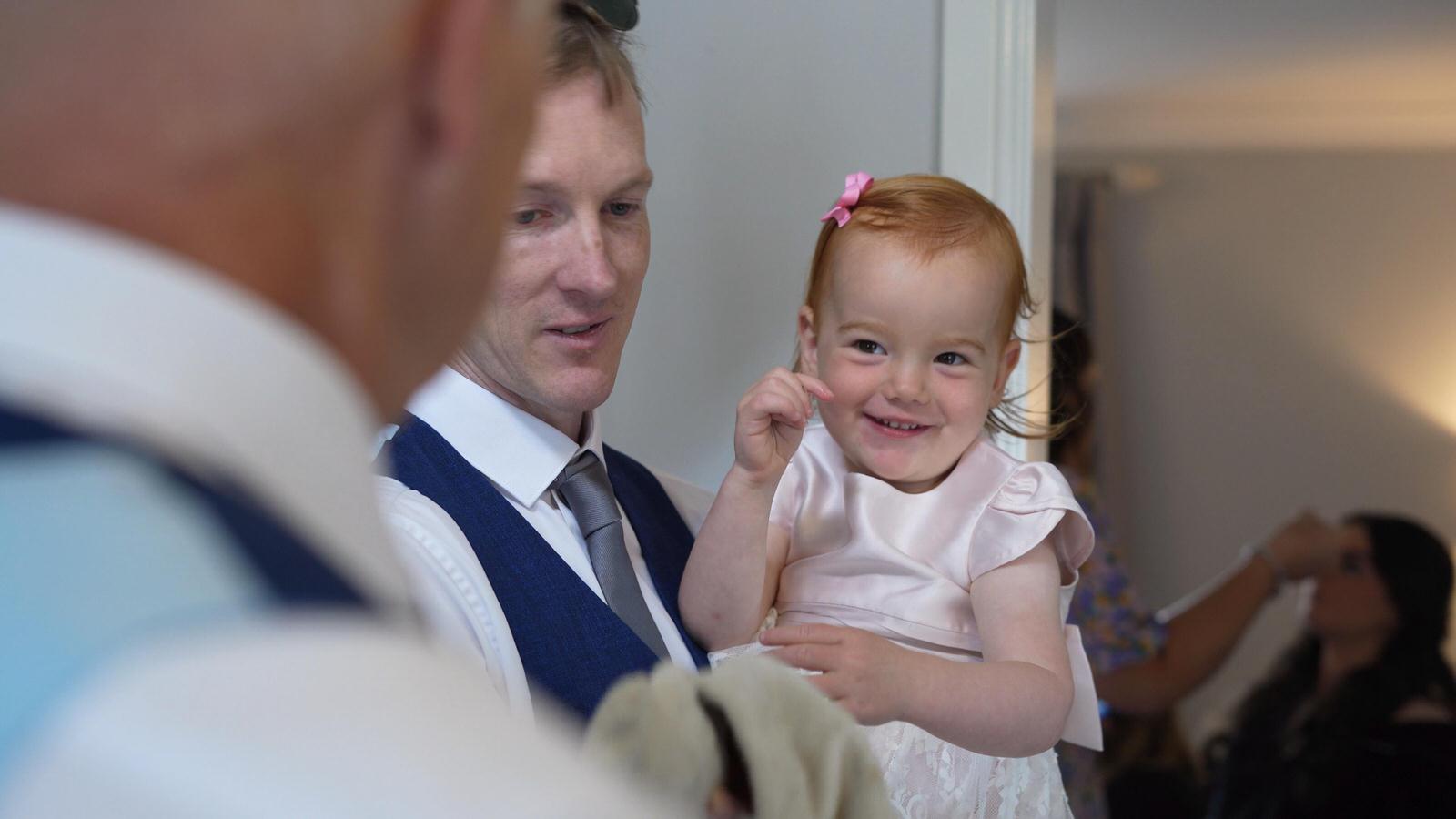 flower girl smiles at father of the bride