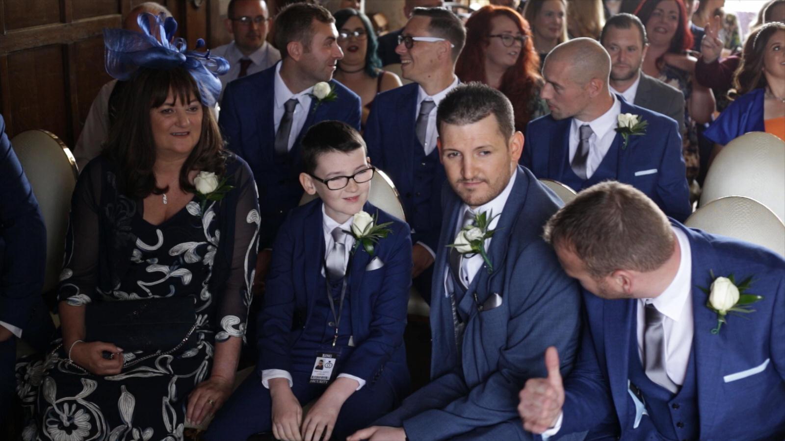 groom sits next to his son and best man at the ceremony