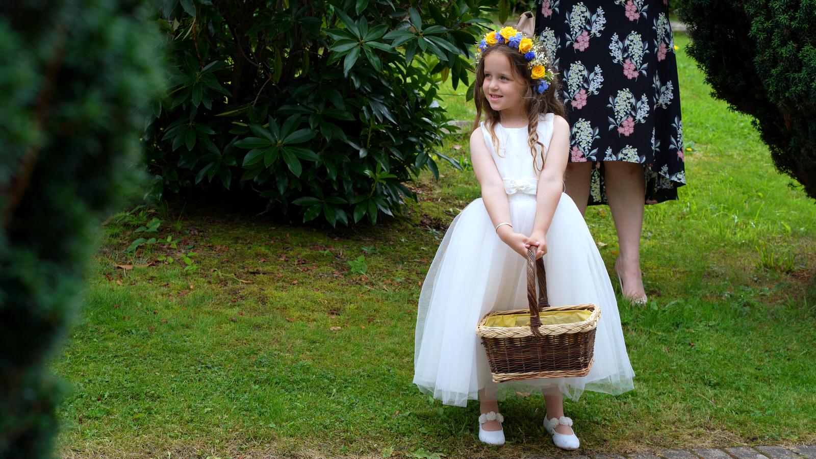 flower girl holds basket of confetti