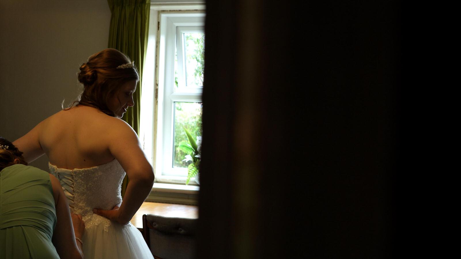 bride gets her wedding dress on