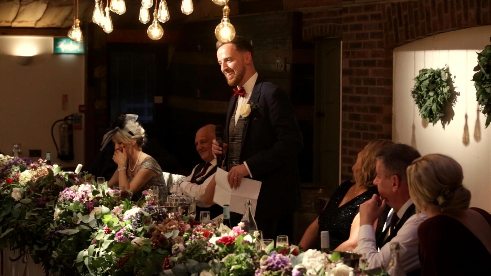 groom makes guests laugh during fun speeches