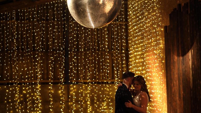 giant glitter ball at Owen House Barn hangs over couple dancing