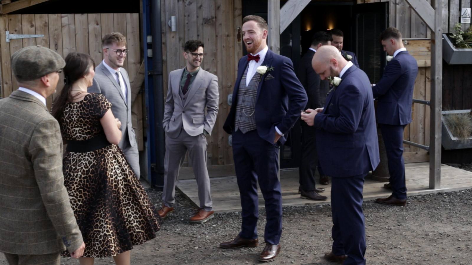 groom chats with guests before owen house wedding