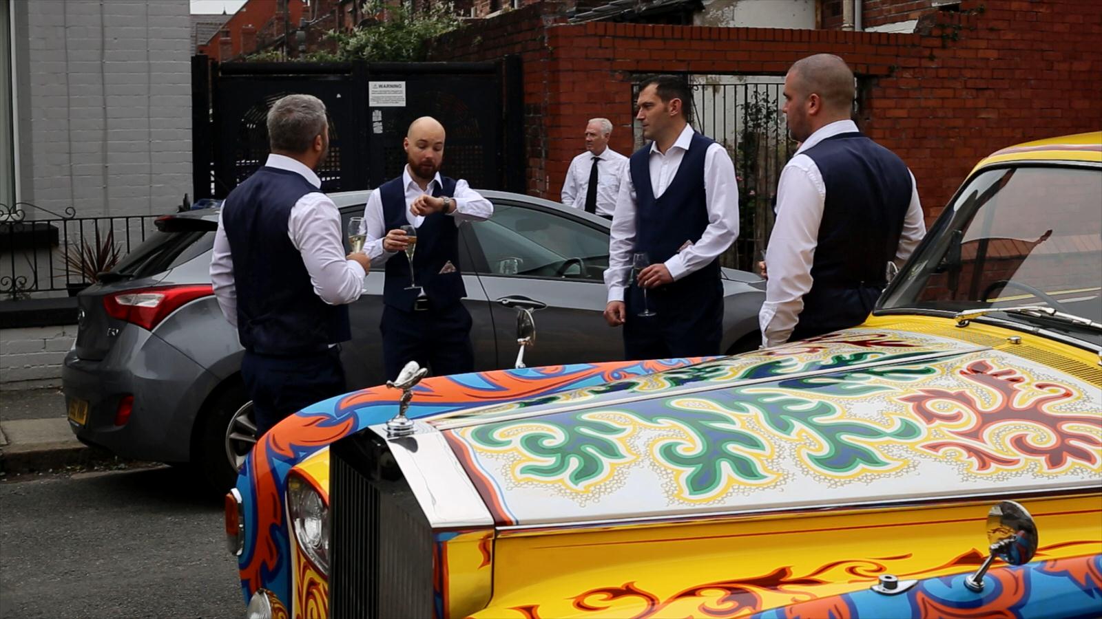 groom stands by John Lennon phantom car