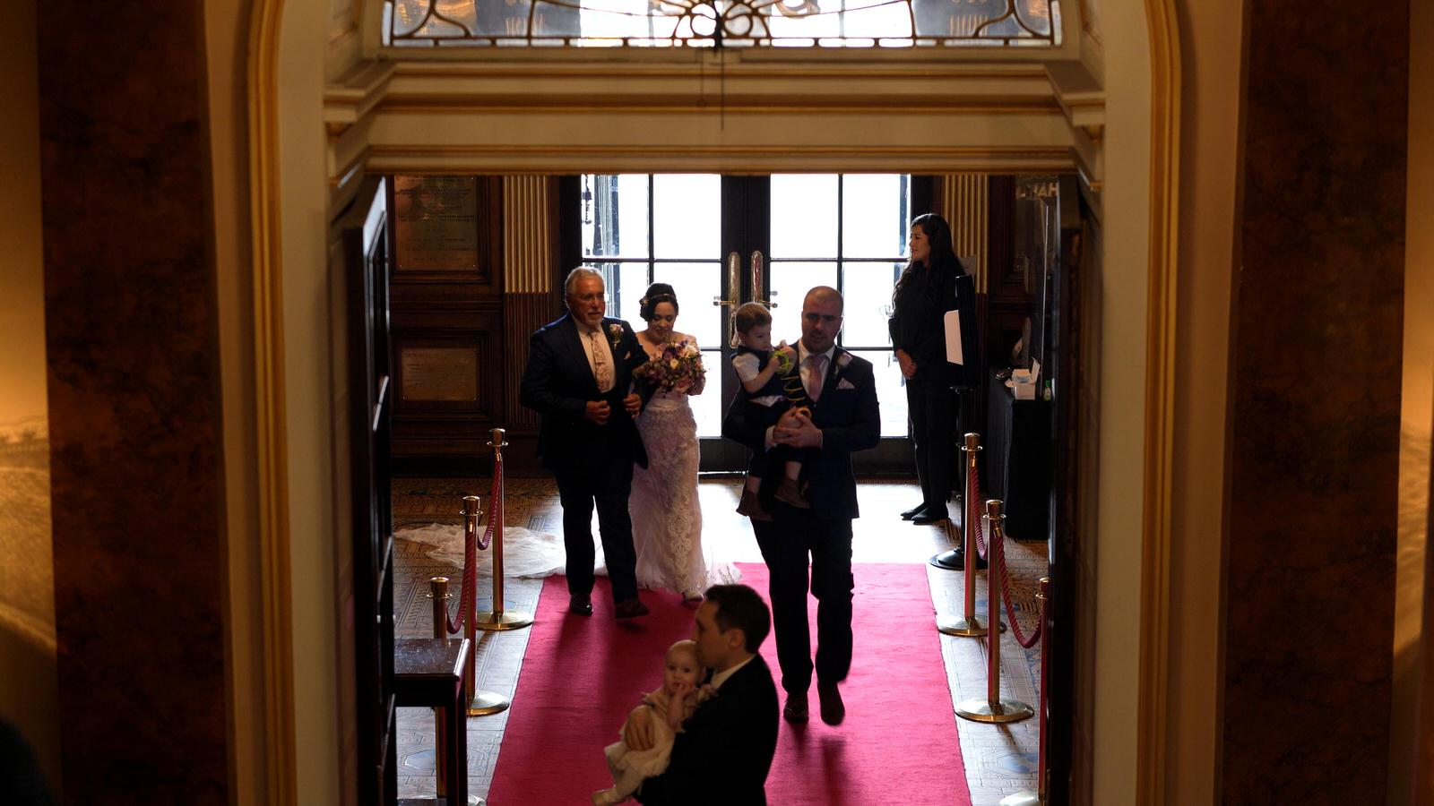 bride and dad walk through town hall entrance