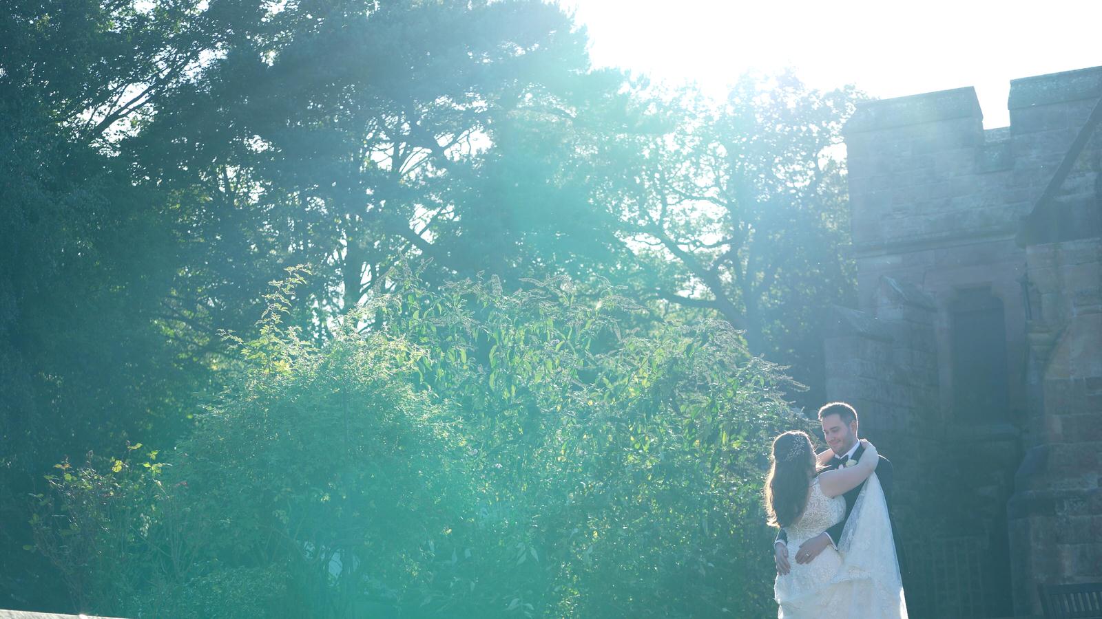 couple kiss under sunlight at peckforton castle