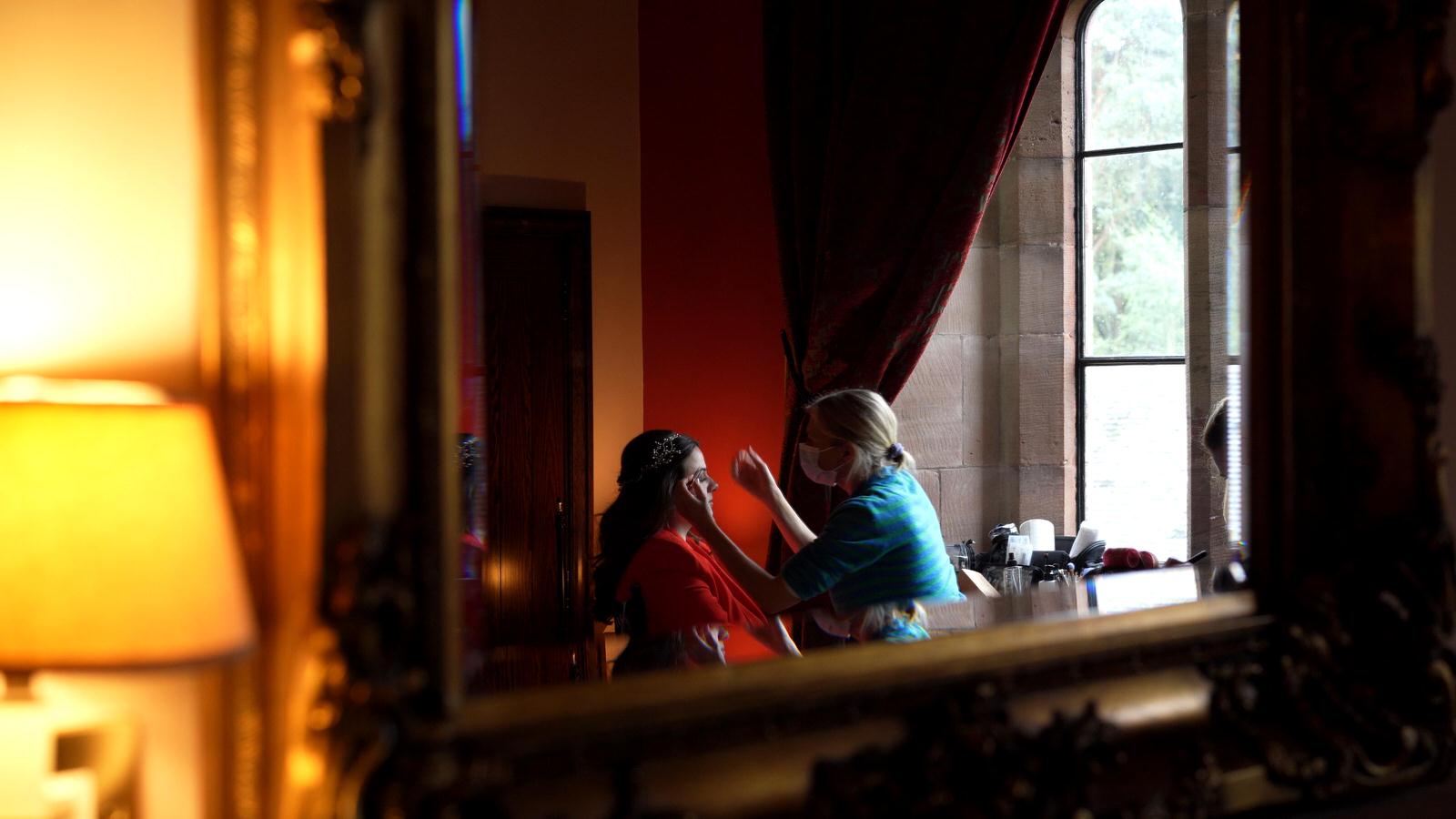 video still of reflection of bride having make up done