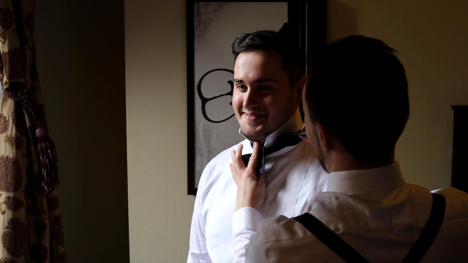 video still of groom in natural light getting ready