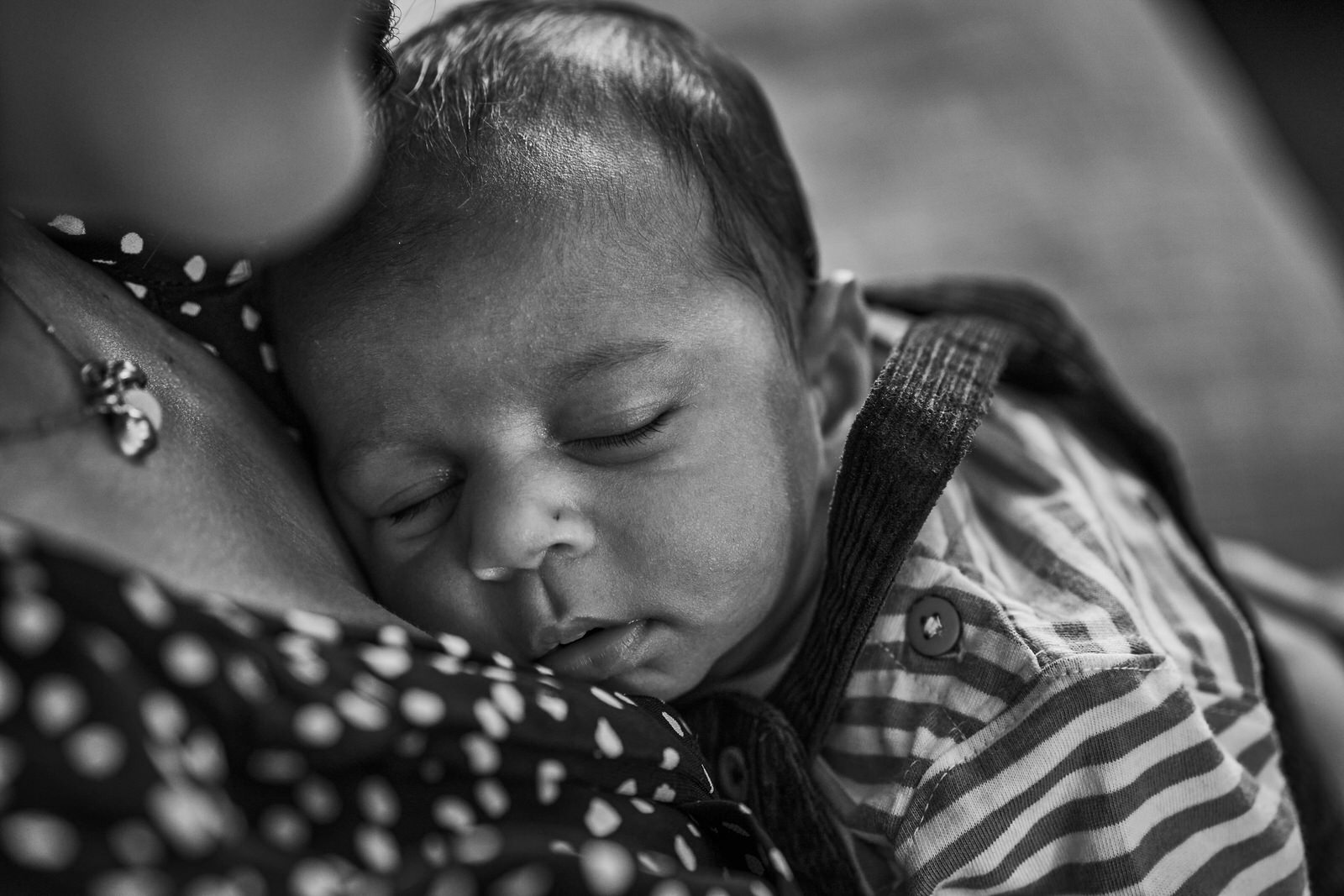 natural photo of newborn baby cuddled on mums chest