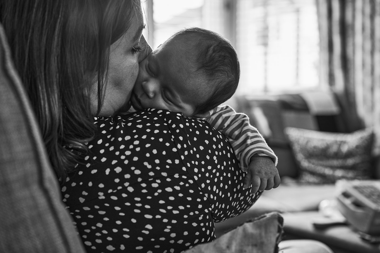 mum kisses babies cheek