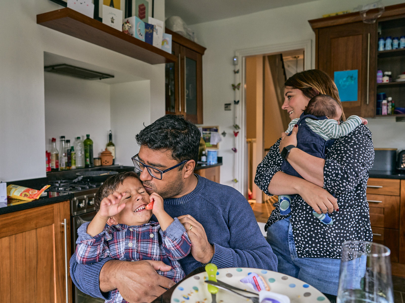 boy screws face up when dad gives him a kiss