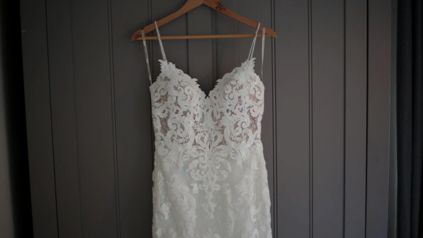 strappy wedding dress hangs up